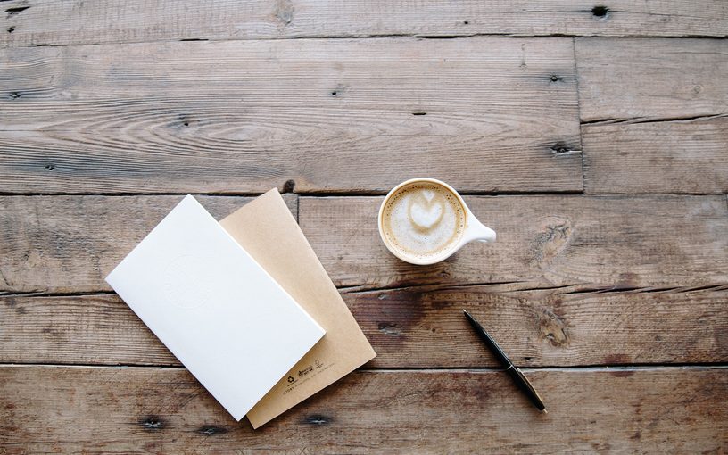 Envelopes, pen and coffee on a wooden table